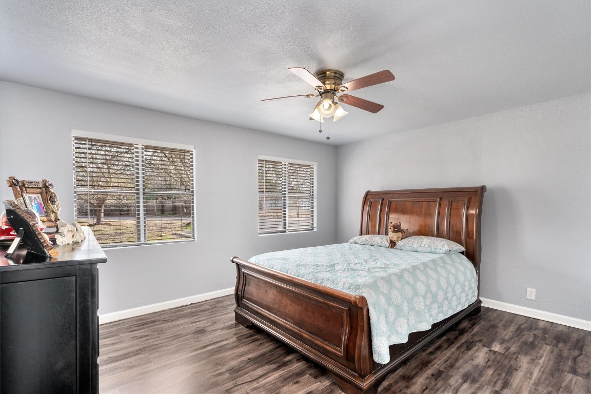 2203 Windy Hill Road Kyle, TX 78640 - Photo 22 of 29 a bedroom with a bed next to a window with a bookshelf