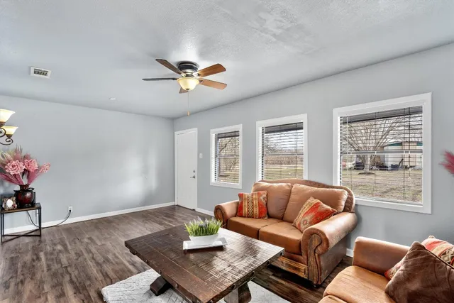 a living room with furniture and wooden floor