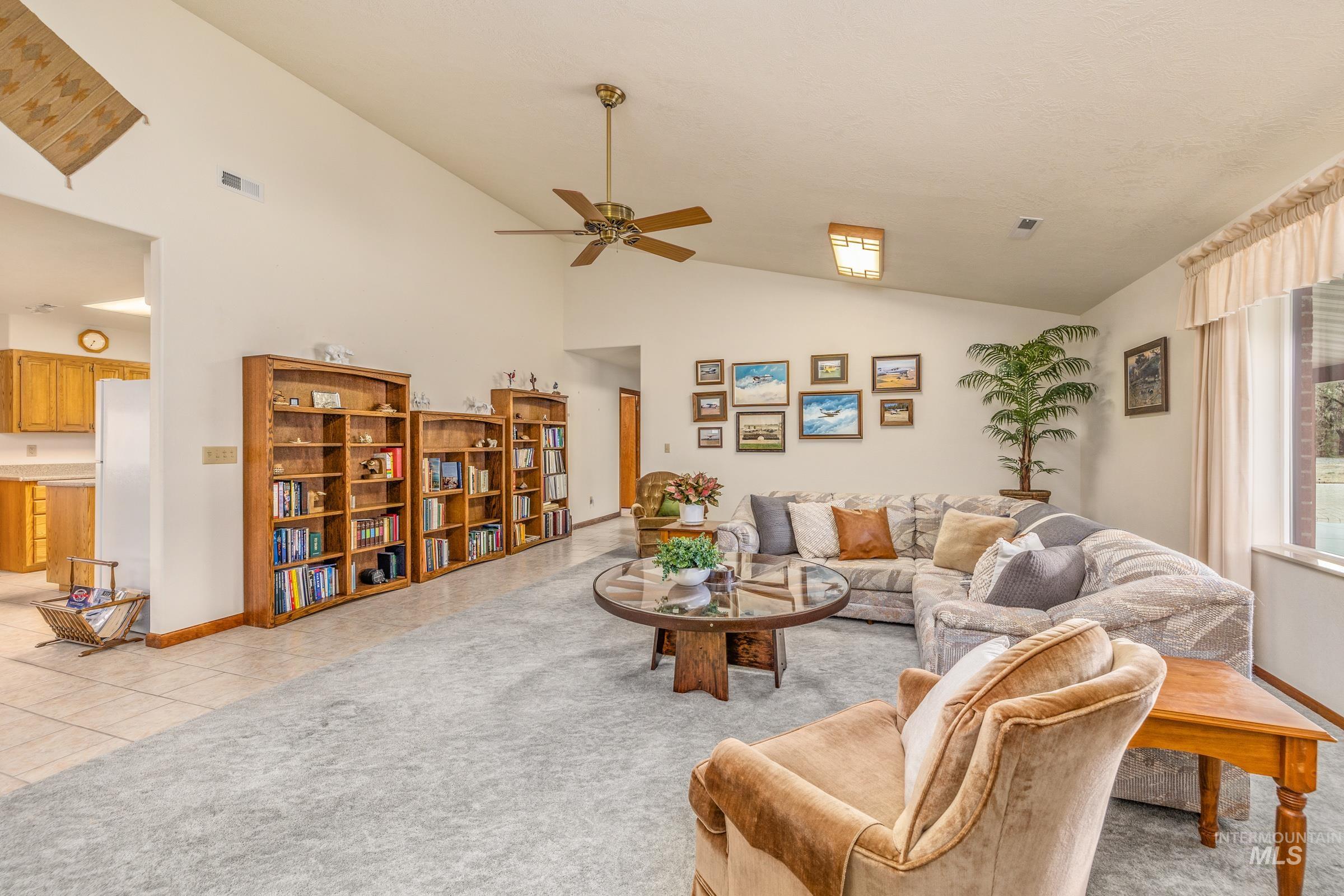 10514 Airpark Loop Road Melba, ID 83641 - Photo 25 of 47 Living area featuring vaulted ceiling, a ceiling fan, and light tile patterned floors