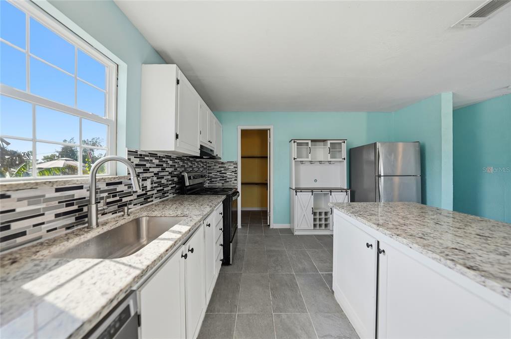 11337 Pineapple Road Punta Gorda, FL 33955 - Photo 7 of 25 a kitchen with stainless steel appliances granite countertop a sink stove and refrigerator