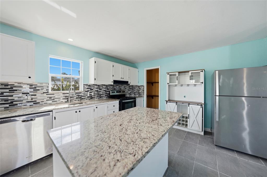 11337 Pineapple Road Punta Gorda, FL 33955 - Photo 8 of 25 a kitchen with stainless steel appliances granite countertop a refrigerator sink stove and white cabinets