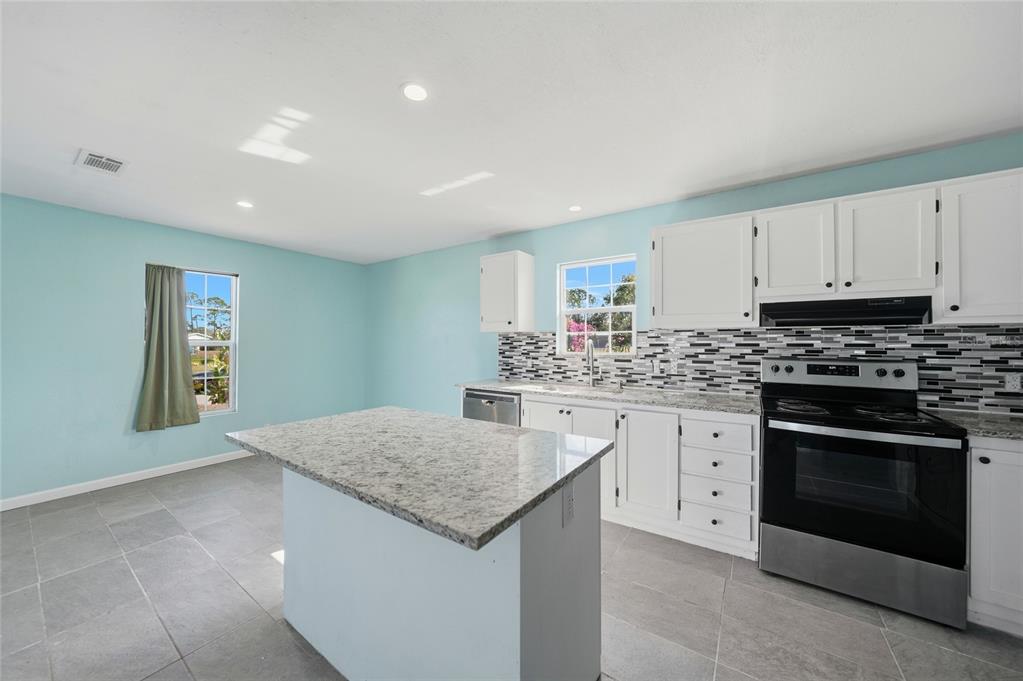 11337 Pineapple Road Punta Gorda, FL 33955 - Photo 9 of 25 a kitchen with granite countertop white cabinets stainless steel appliances and a window
