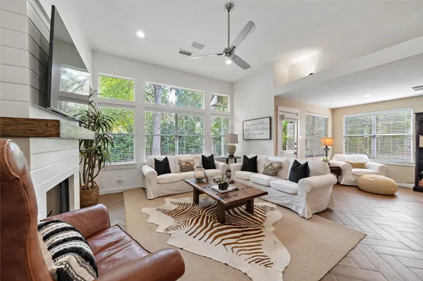 a living room with furniture fireplace and a large window