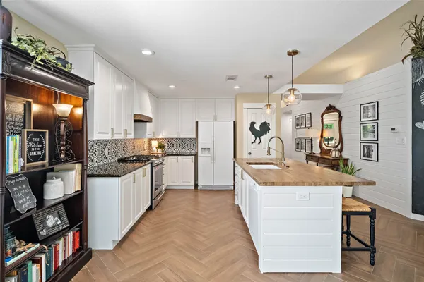 a large kitchen with stainless steel appliances granite countertop a lot of counter space and a refrigerator