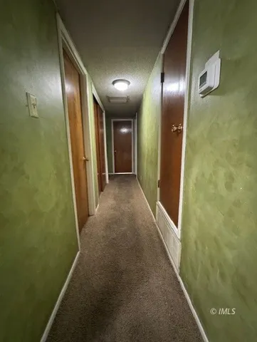 a bedroom with a bed and a flat tv screen on dresser