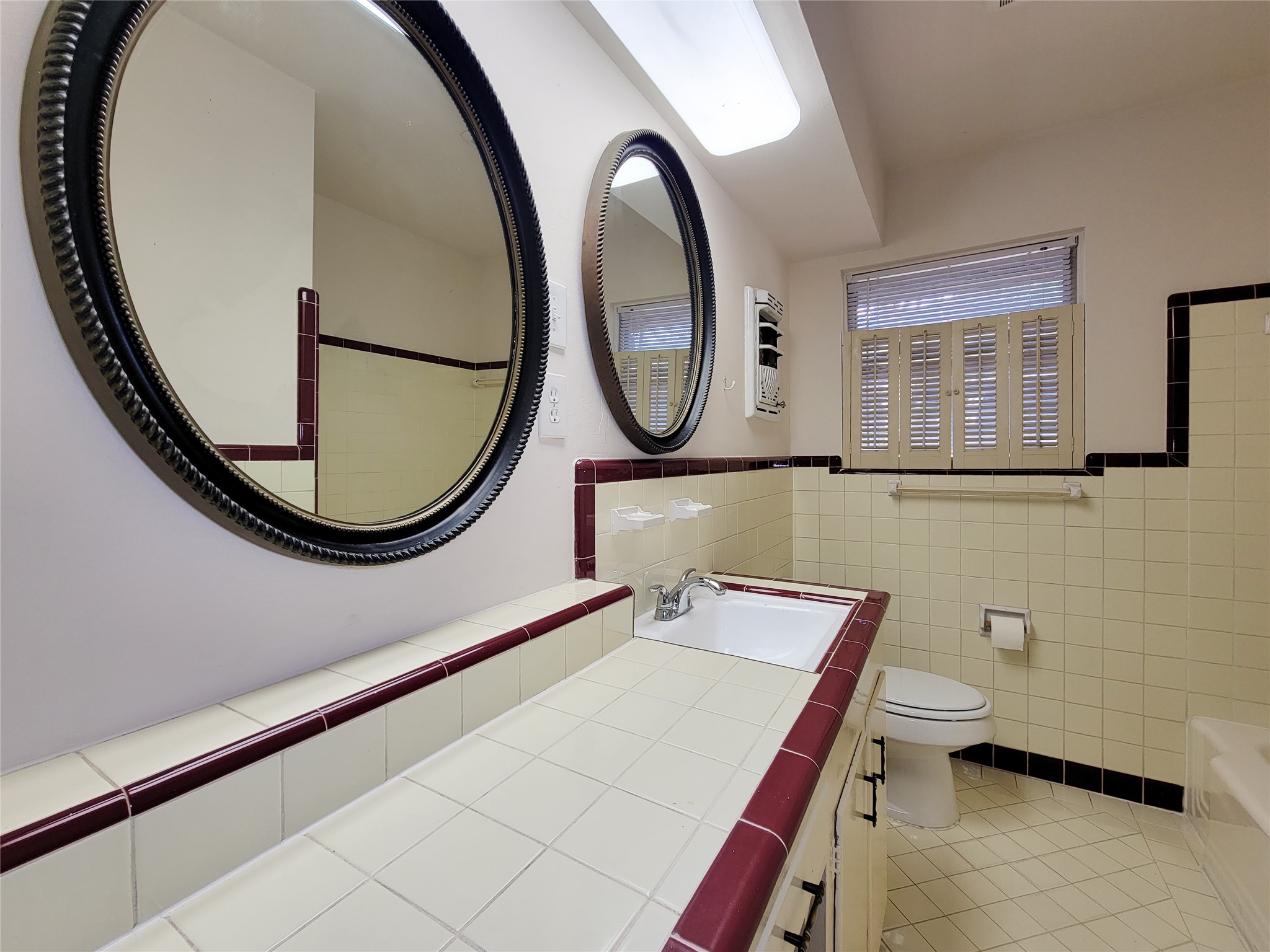 5442 Kinglet Street Houston, TX 77096 - Photo 17 of 25 a bathroom with a sink a mirror and a toilet