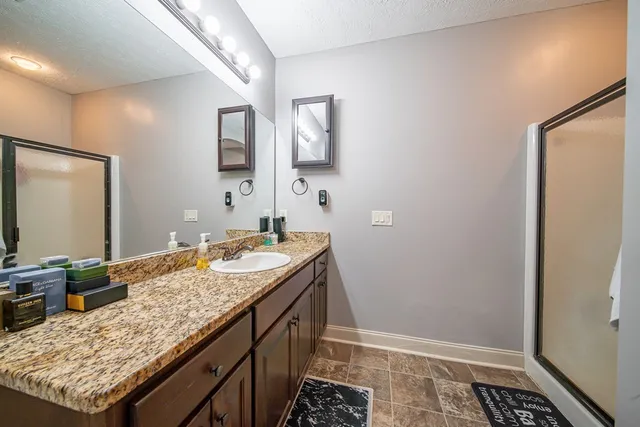 a bathroom with a granite countertop sink and a mirror