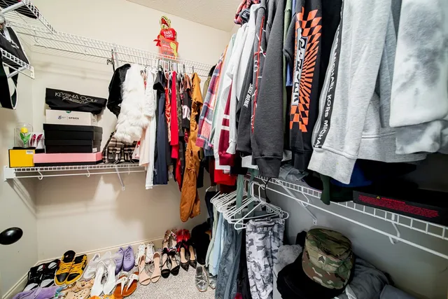 a view of walk in closet with clothes