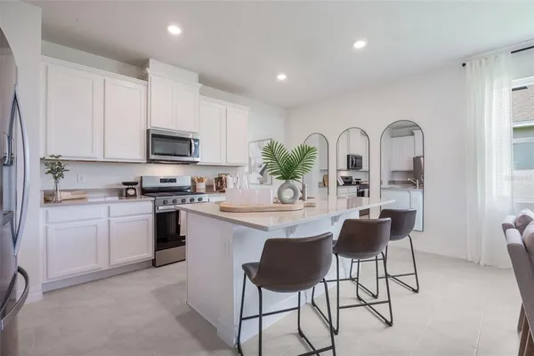 a kitchen with stainless steel appliances granite countertop a stove a sink a refrigerator and a microwave