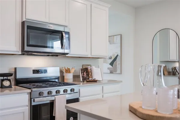 a kitchen with stainless steel appliances granite countertop a stove and a microwave