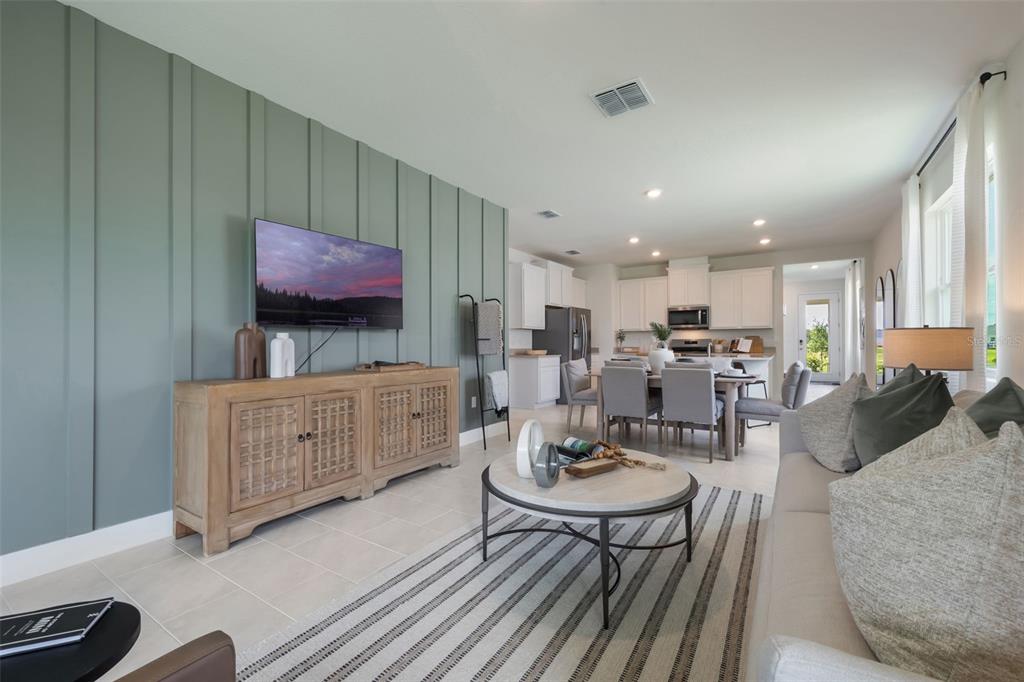 3961 Kennebunk Loop Mount Dora, FL 32757 - Photo 21 of 51 a living room with furniture a flat screen tv and kitchen view