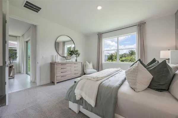 a bedroom with a bed a table and a large window