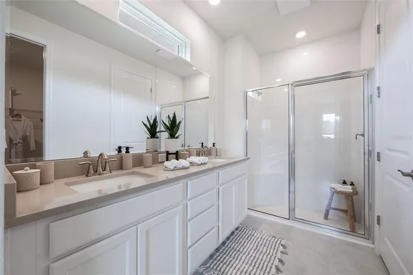 a bathroom with a double vanity sink mirror and shower