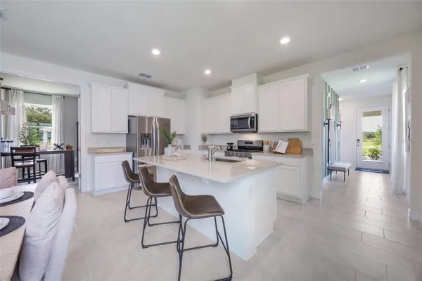 a kitchen with a dining table chairs refrigerator and cabinets
