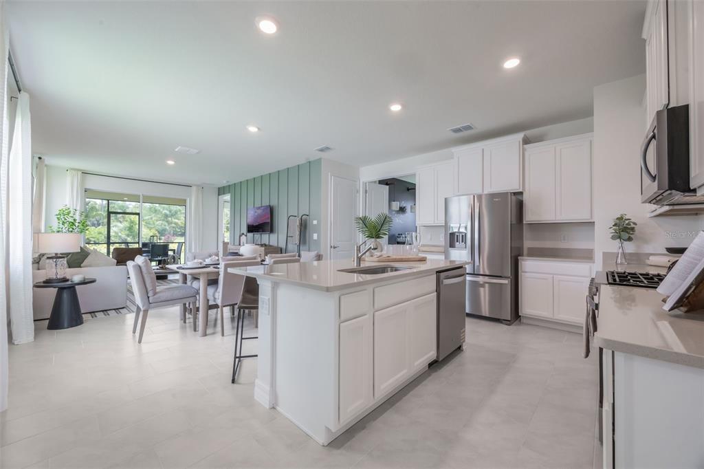 3961 Kennebunk Loop Mount Dora, FL 32757 - Photo 8 of 51 a kitchen with white cabinets and stainless steel appliances