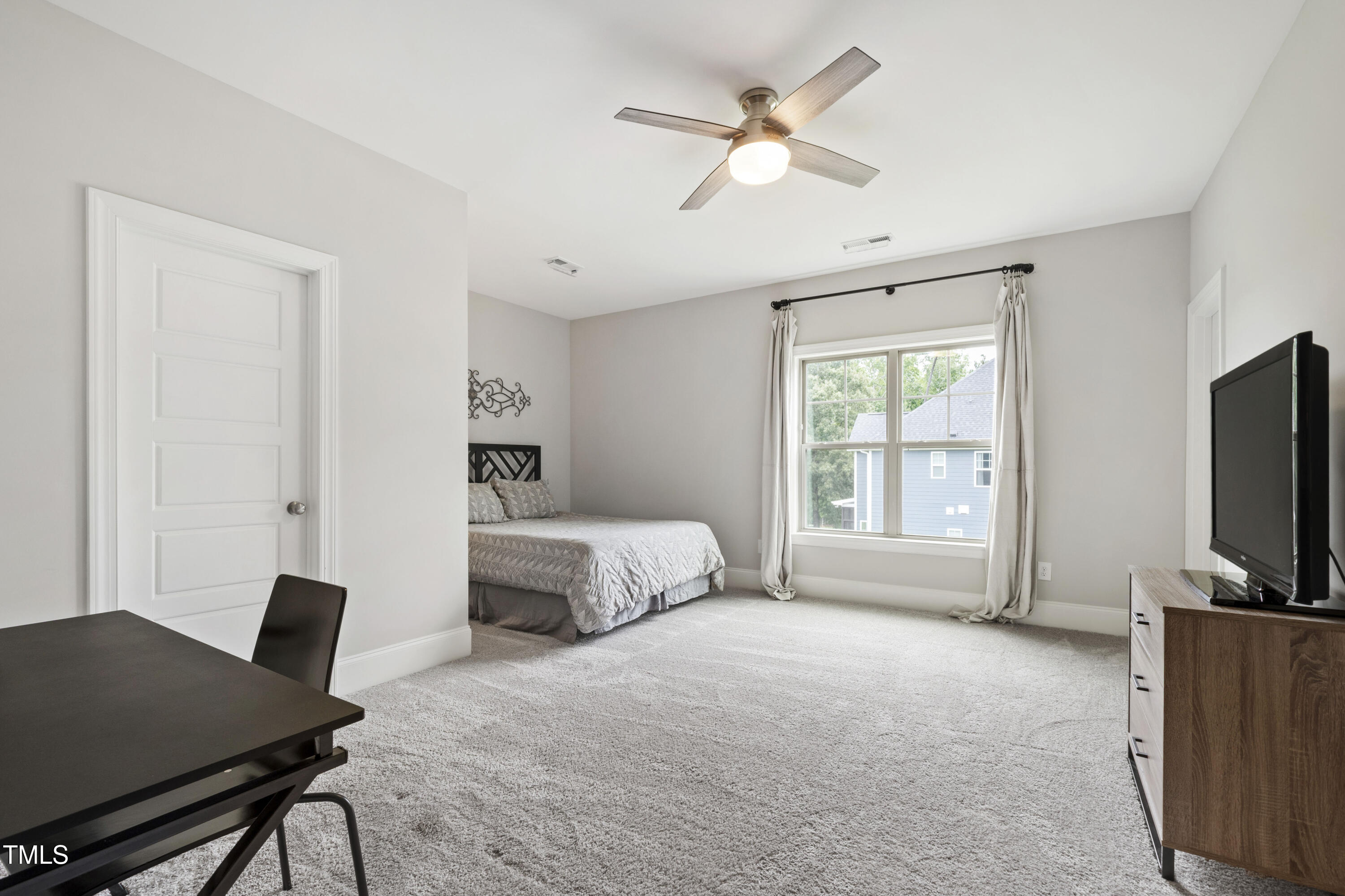 4212 Banks Stone Drive Raleigh, NC 27603 - Photo 47 of 69 a bedroom with a bed a chandelier and a flat screen tv