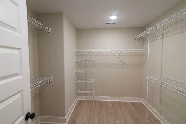 a view of a room with wooden floor pendant lights and windows