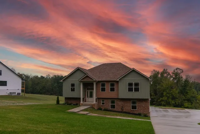 a front view of a house with a garden and yard