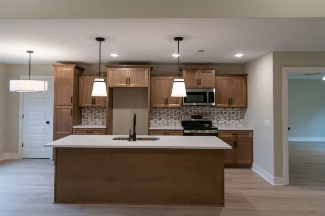 a kitchen with kitchen island a sink stainless steel appliances and counter space