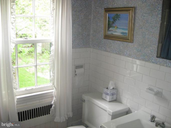 5706 Kenmore Road Baltimore, MD 21210 - Photo 11 of 18 a bathroom with a toilet a sink and a window