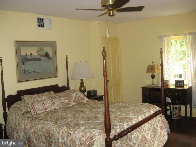 5706 Kenmore Road Baltimore, MD 21210 - Photo 7 of 18 a bedroom with a bed and a table in it
