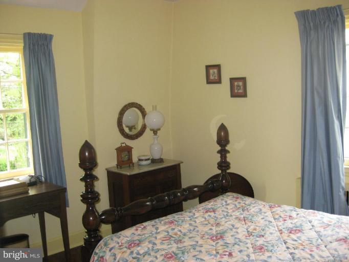 5706 Kenmore Road Baltimore, MD 21210 - Photo 10 of 18 a bedroom with a bed and a chandelier