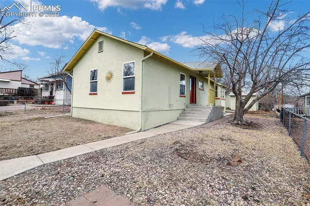 a view of a white house with a yard