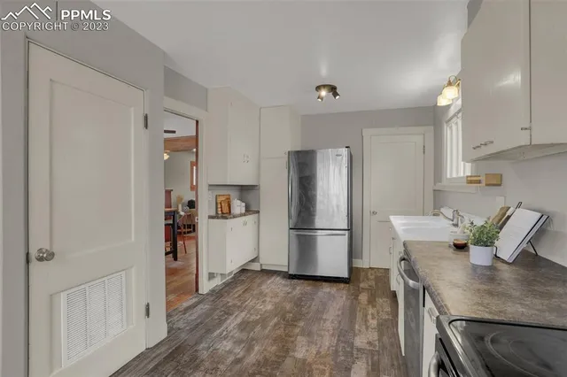 a kitchen with refrigerator cabinets and wooden floor