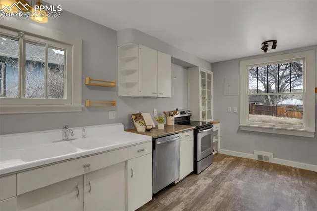a kitchen with stainless steel appliances granite countertop a sink stove and cabinets
