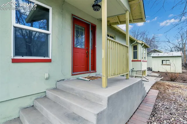 a view of a house with backyard and sitting area