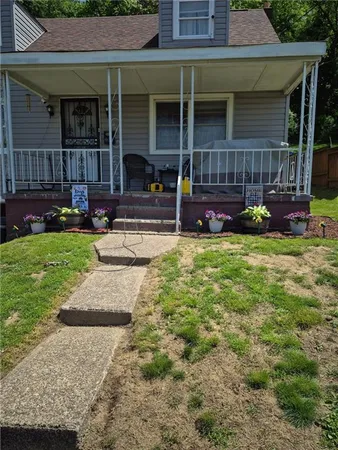 a view of a house with a yard and sitting area
