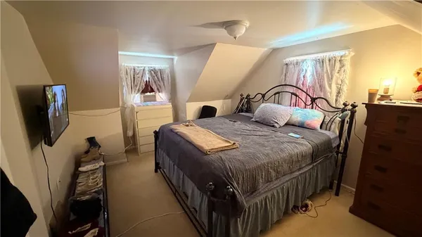 a bedroom with a bed a flat screen tv and dresser