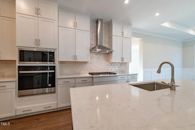 a kitchen with stainless steel appliances granite countertop a stove a sink and a refrigerator