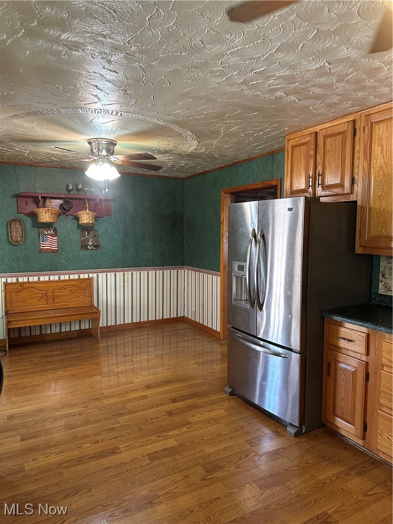 167 Andover Road Woodsfield, OH 43793 - Photo 23 of 50 Kitchen with fridge, light wood finished floors, a ceiling fan, Amish Built Oak cabinetry, and dark countertops