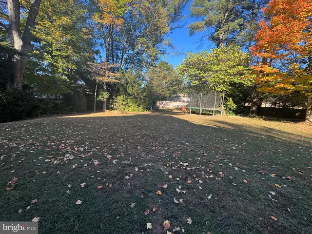 a large kitchen with kitchen island a stove a sink dishwasher a dining table and chairs with wooden floor