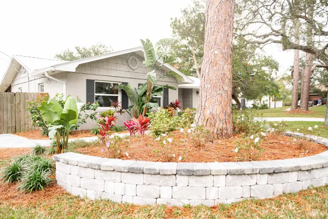 a view of a white house with a yard patio and fire pit