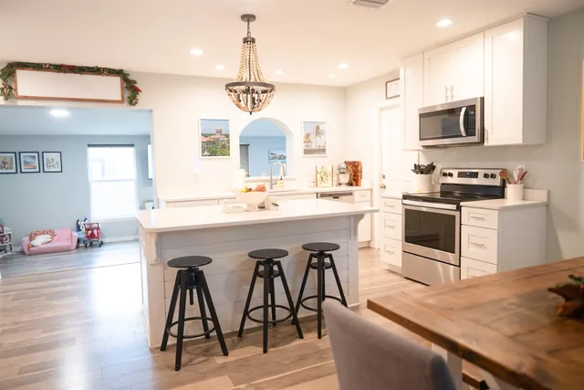 a kitchen with stainless steel appliances a table chairs sink and microwave
