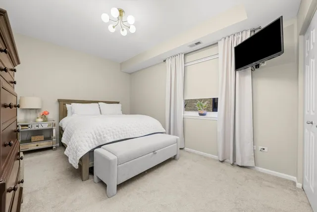 a bedroom with a bed and a flat tv screen on the dresser