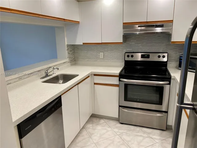 a kitchen with granite countertop a stove sink and cabinets