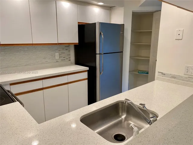a kitchen with a sink and a refrigerator