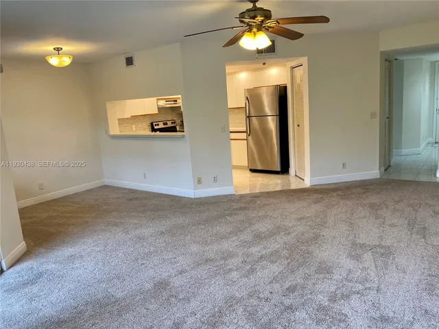 an empty room with a mirror and fan