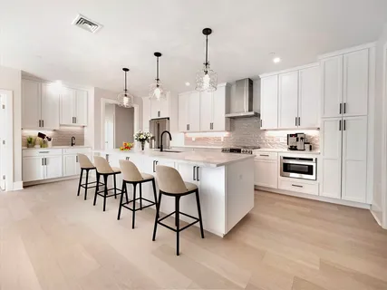 a kitchen with kitchen island granite countertop a sink cabinets and stainless steel appliances