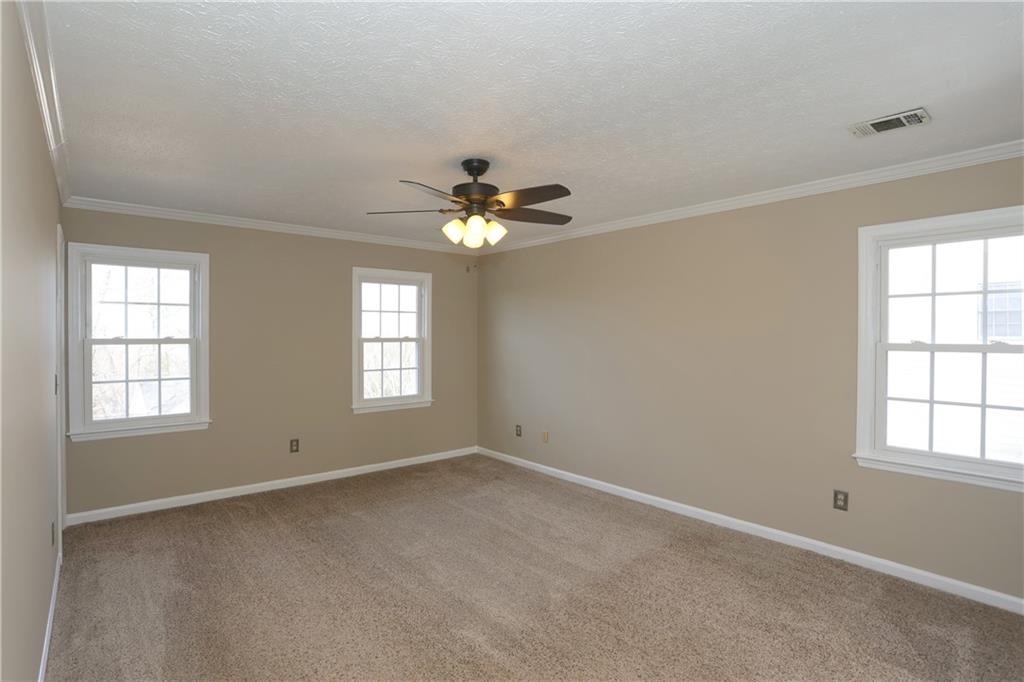4981 Shallow Ridge Road Northeast Kennesaw, GA 30144 - Photo 21 of 36 an empty room with windows and chandelier fan