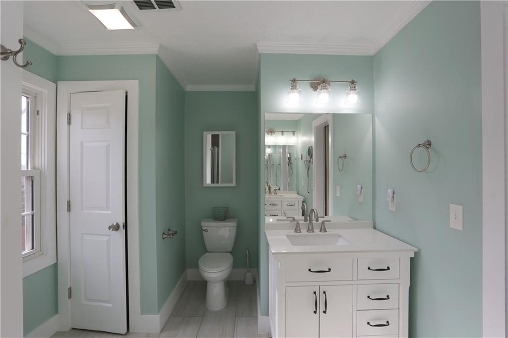 4981 Shallow Ridge Road Northeast Kennesaw, GA 30144 - Photo 27 of 36 a bathroom with a toilet a sink a mirror and vanity