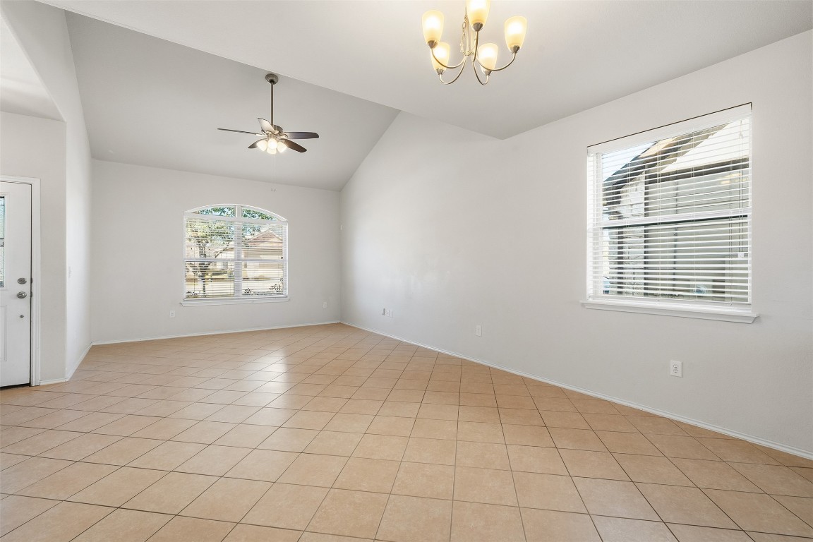 160 Albatross Cove Buda, TX 78610 - Photo 11 of 36 an empty room with windows and chandelier fan