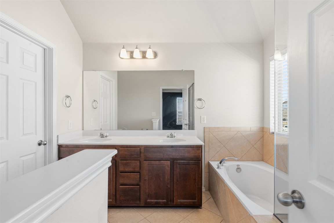 160 Albatross Cove Buda, TX 78610 - Photo 21 of 36 a spacious bathroom with a tub sink and mirror