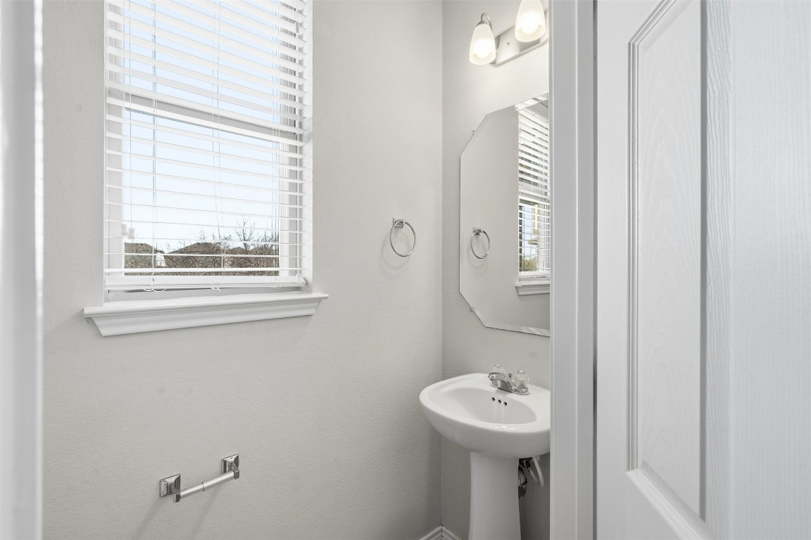 160 Albatross Cove Buda, TX 78610 - Photo 29 of 36 a bathroom with a sink a mirror and a window