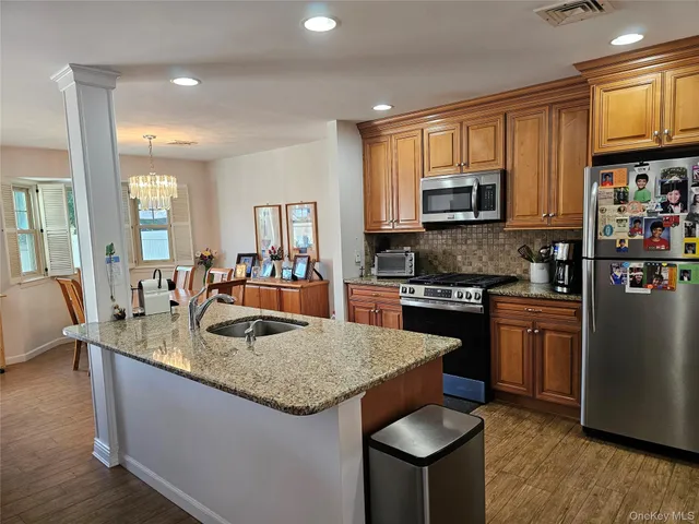 a living room with kitchen island furniture a kitchen view and a sink