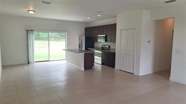 a view of a kitchen with furniture and an empty room