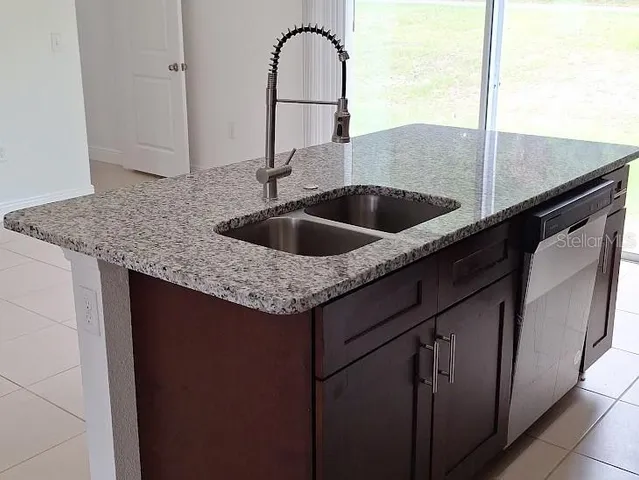 a kitchen with a granite countertop sink and has a sink